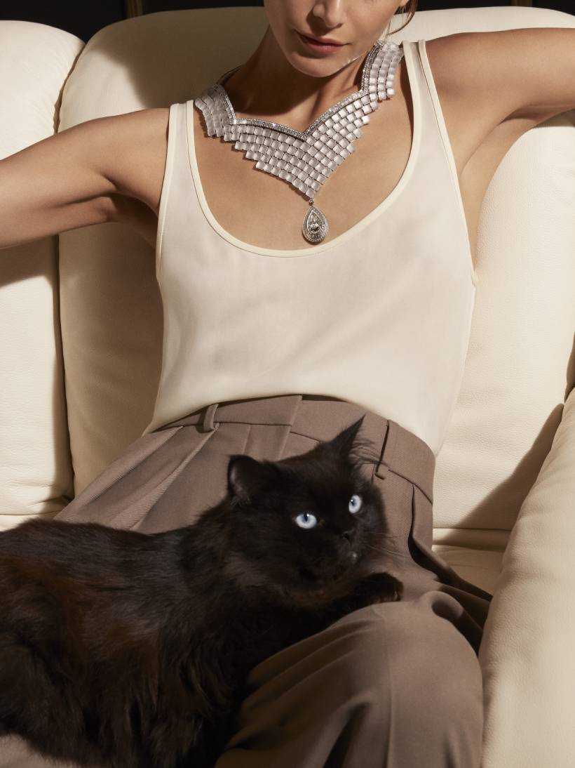 model wearing carte blanche paris vu du 26 collection necklace with Wladimir, the cat, on her lap